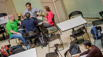 4 people sitting around a table having a discussion