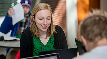 Girl looking at the computer smiling 